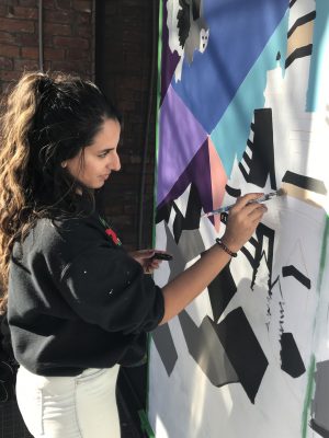 Toronto-based artist Jasmin Pannu painting a storefront window in The Junction for the Window Wonderland exhibition, the city’s first augmented reality outdoor art exhibition.