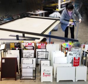 Seen here, staff fabricates plexiglass stands and welds custom A-frames.