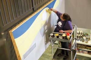 Anishinaabe artist Jeannette Ladd paints a new mural in the lobby of the Huron County Museum.