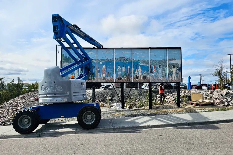 A crane places the mural. 