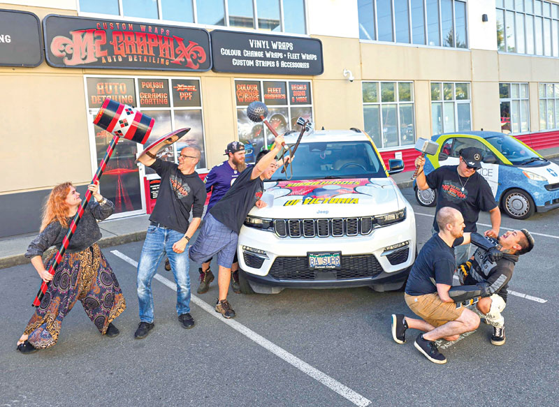 The M2 Graphix team poses with the superhero car. 